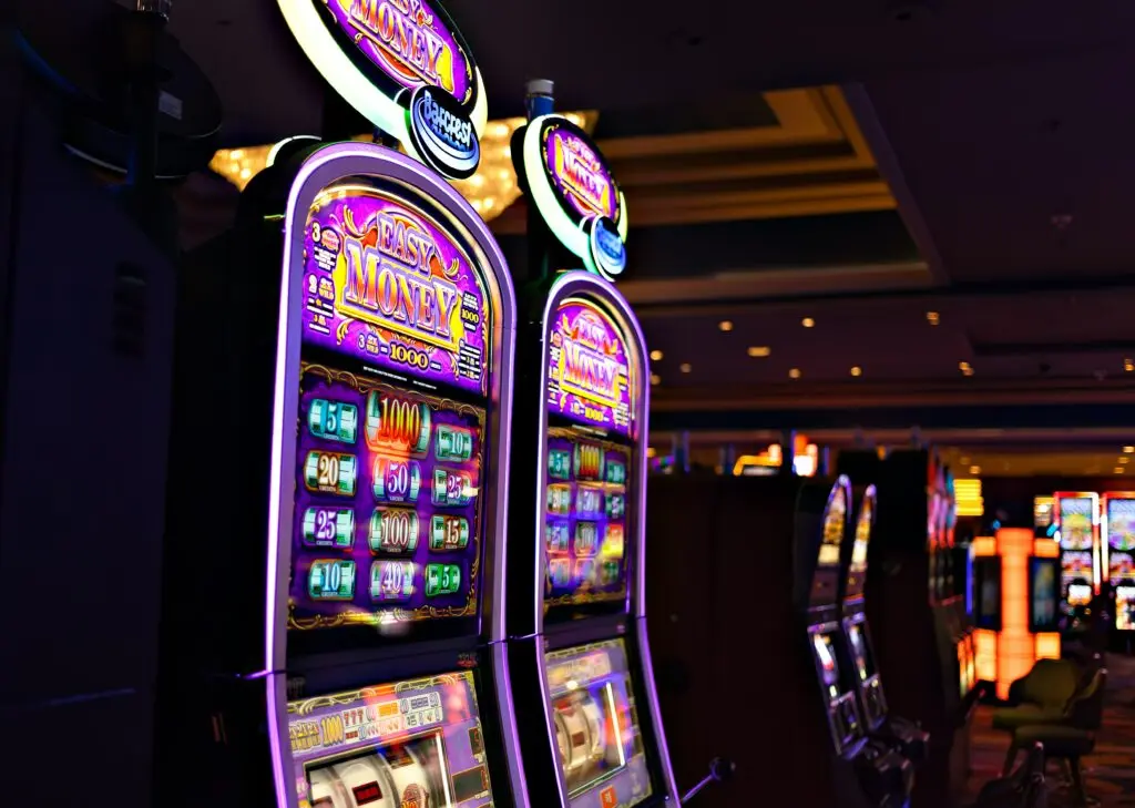 A row of lit slot machines on a casino floor